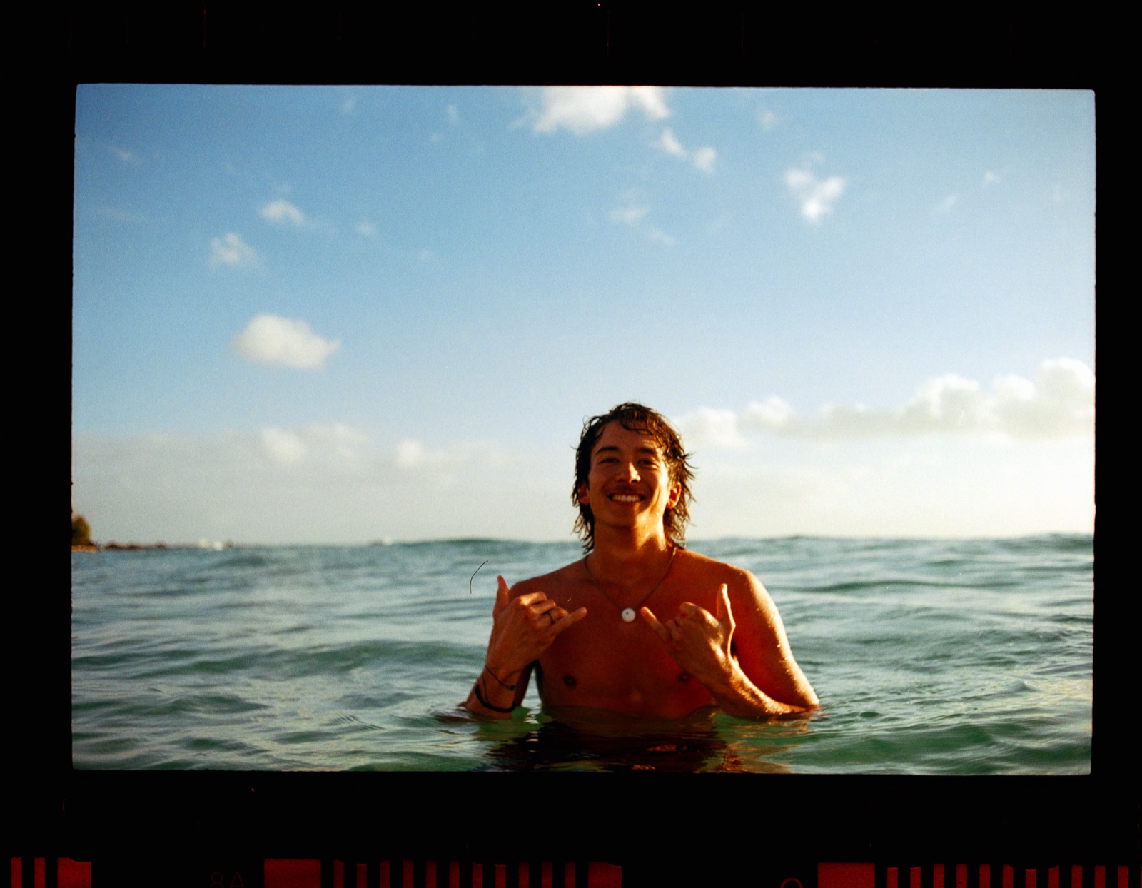 Kaulike Jansen in the water off Maui, throwing shakas